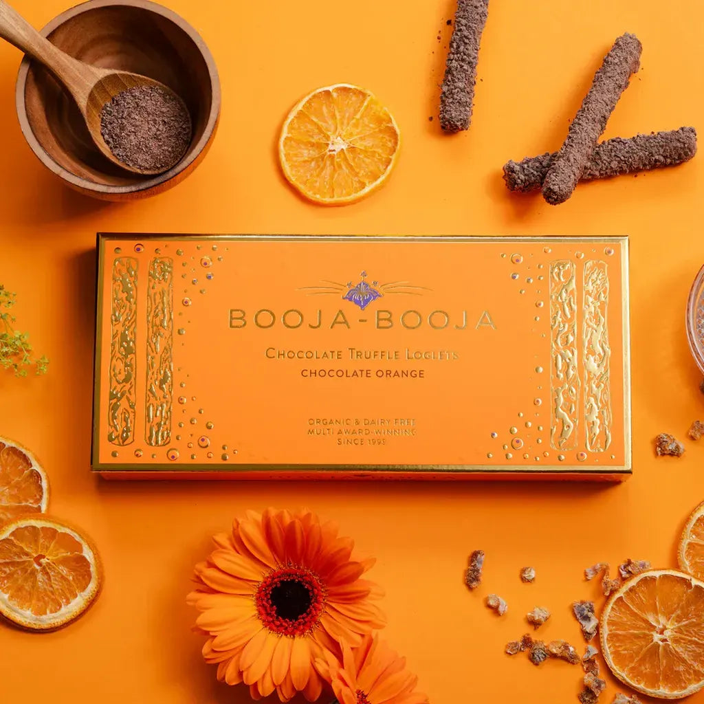 Booja Booja Loglets Chocolate Orange box with chocolate truffles, orange slices, and cocoa scatters.