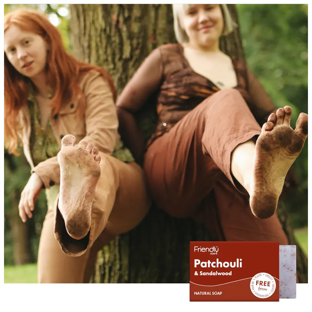 Two women sitting outdoors with a 'Friendly Soap' patchouli and sandalwood bar soap in the foreground.