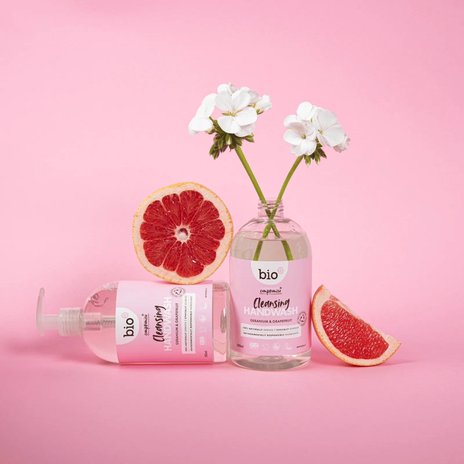 Bio-D Hand Wash Geranium & Grapefruit 500ml Front facing lifestyle picture with sliced grapefruit and geranium plant.