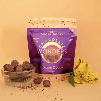 Booja Booja Wonders Cookie Dough package with chocolate treats, vegan, gluten-free, and organic, surrounded by flowers.