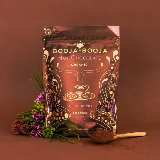 Booja Booja Hot Chocolate Organic packaging with rich cocoa and flowers on brown background.
