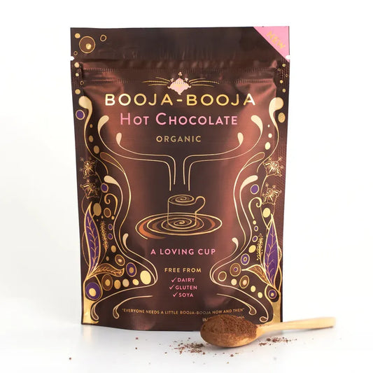 Booja Booja Hot Chocolate Organic packet with a wooden scoop, showcasing vegan and dairy-free options.