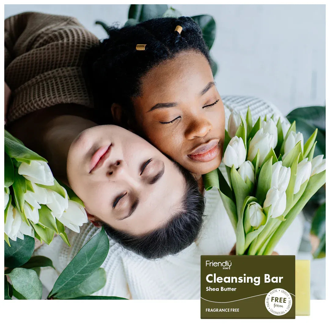 Two people lying down with flowers, featuring a 'Friendly Soap' cleansing bar in the corner.