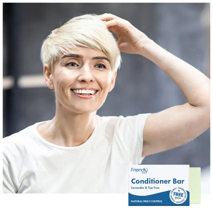 Woman with short blonde hair touching her hair, with a Friendly Soap conditioner bar ad overlay.