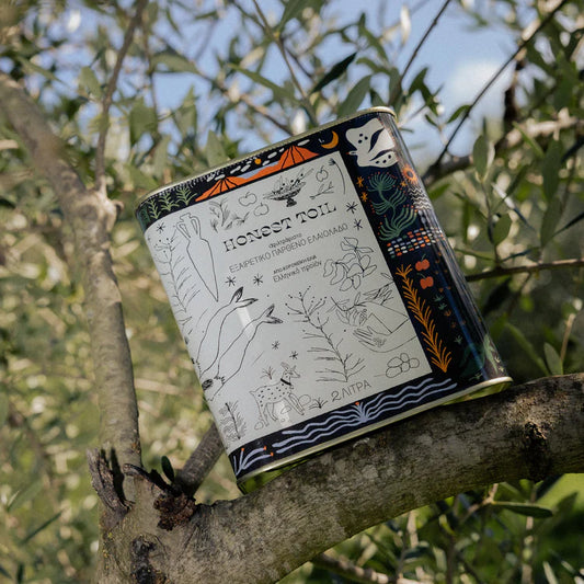 Honest Toil Olive Oil 2 Litre can displayed on an olive tree, showcasing its premium packaging and design.