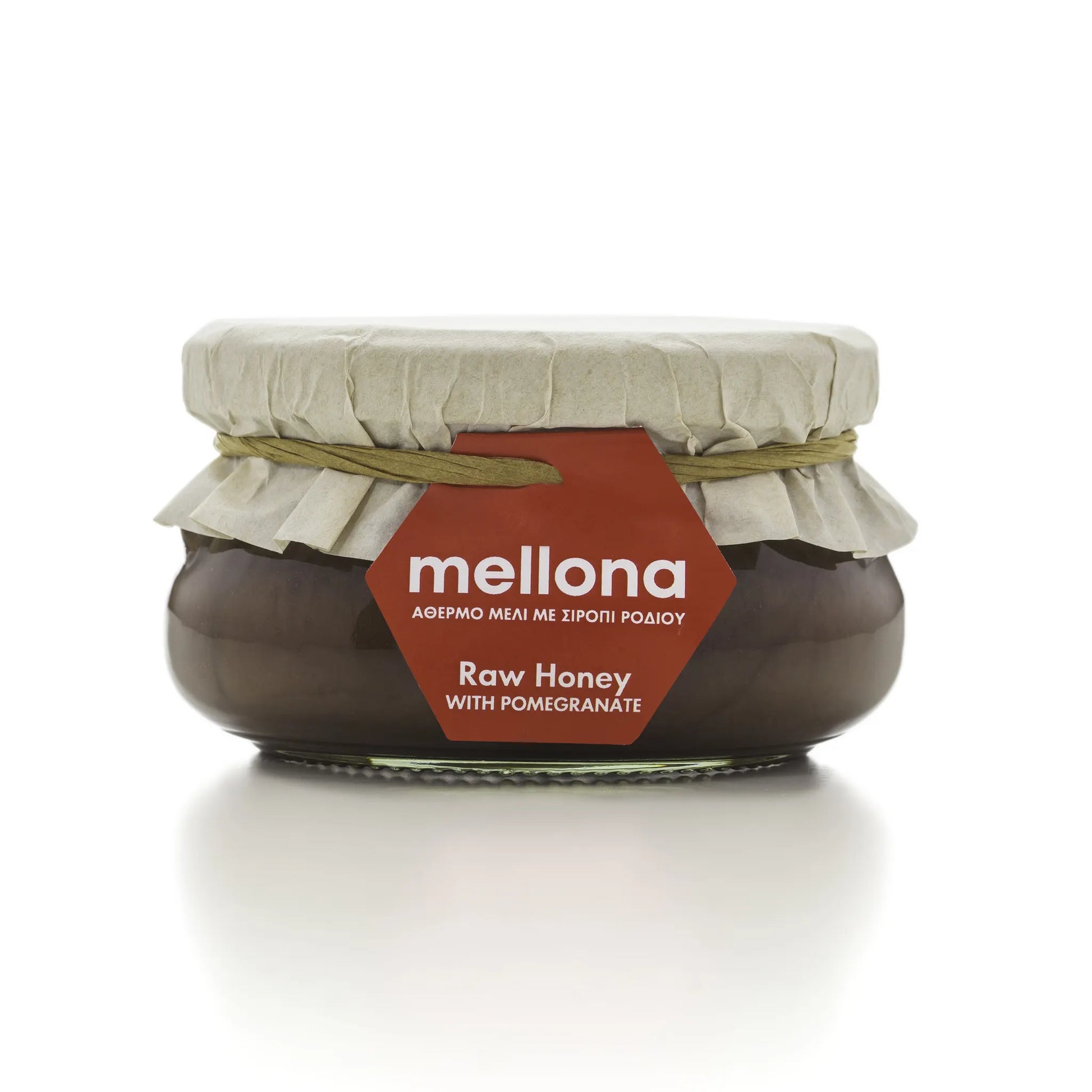 Mellona Raw Honey with Pomegranate in a jar featuring a decorative label and natural packaging.